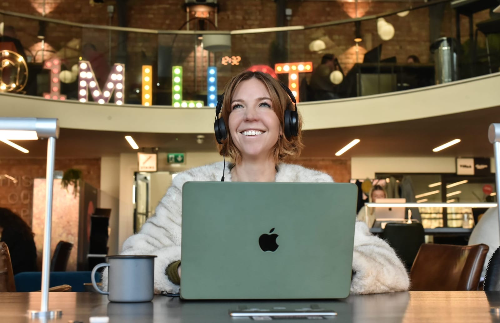Member wearing headphones at a hot desk in the coworking space at 1 Mill Street, Leamington Spa
