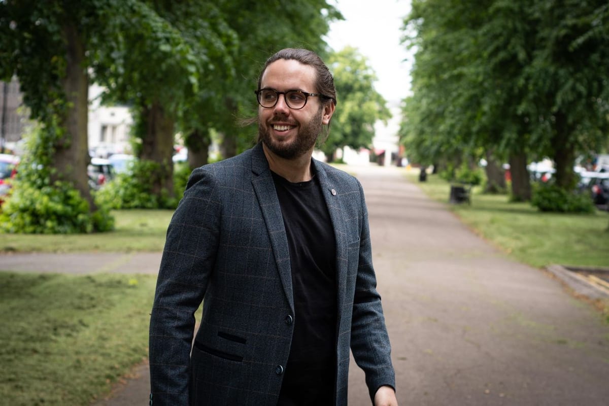 Luke Broadhurst of Rooost smiling on a tree-lined path in Leamington Spa