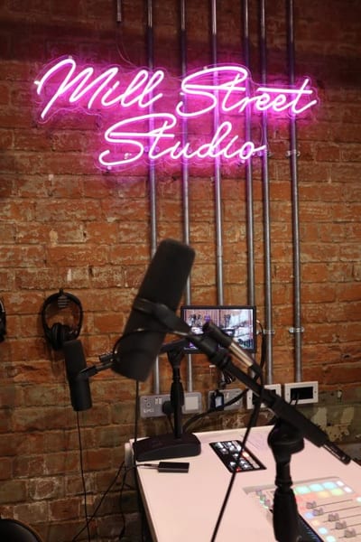 A podcast microphone under neon light in the content studio